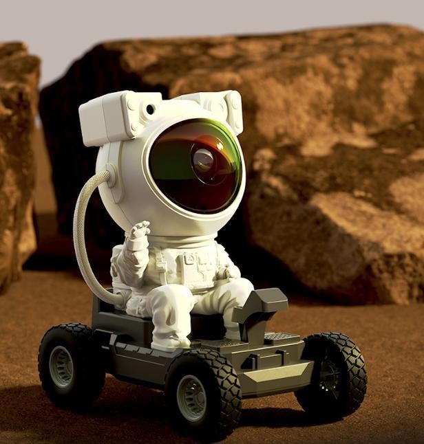 White astronaut on an all-terrain rover Sky Projector positioned on rocky planet terrain mockup.