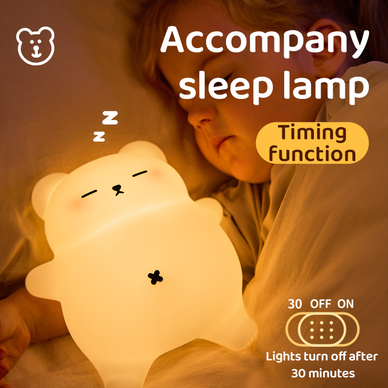 Young child sleeping peacefully in bed next to a warm glowing, bear-shaped night light featuring a 30-minute auto-off timer setting graphic.