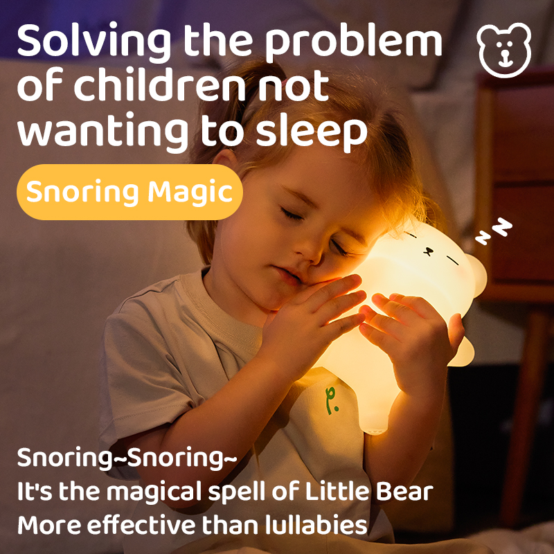 Little girl lying in bed resting her cheek against a soft, glowing, bear-shaped night light with its eyes closed in a sleeping pose.